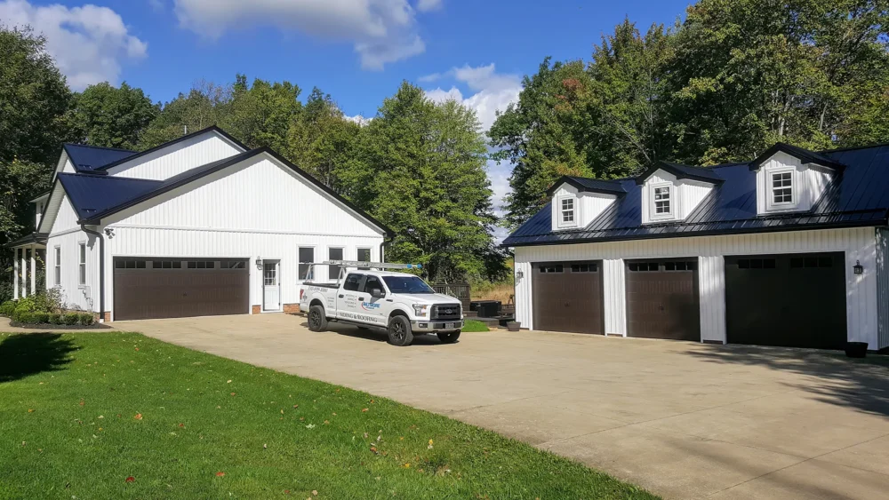 Board and batten siding, metal roofing, gutters, windows, patio and garage doors.