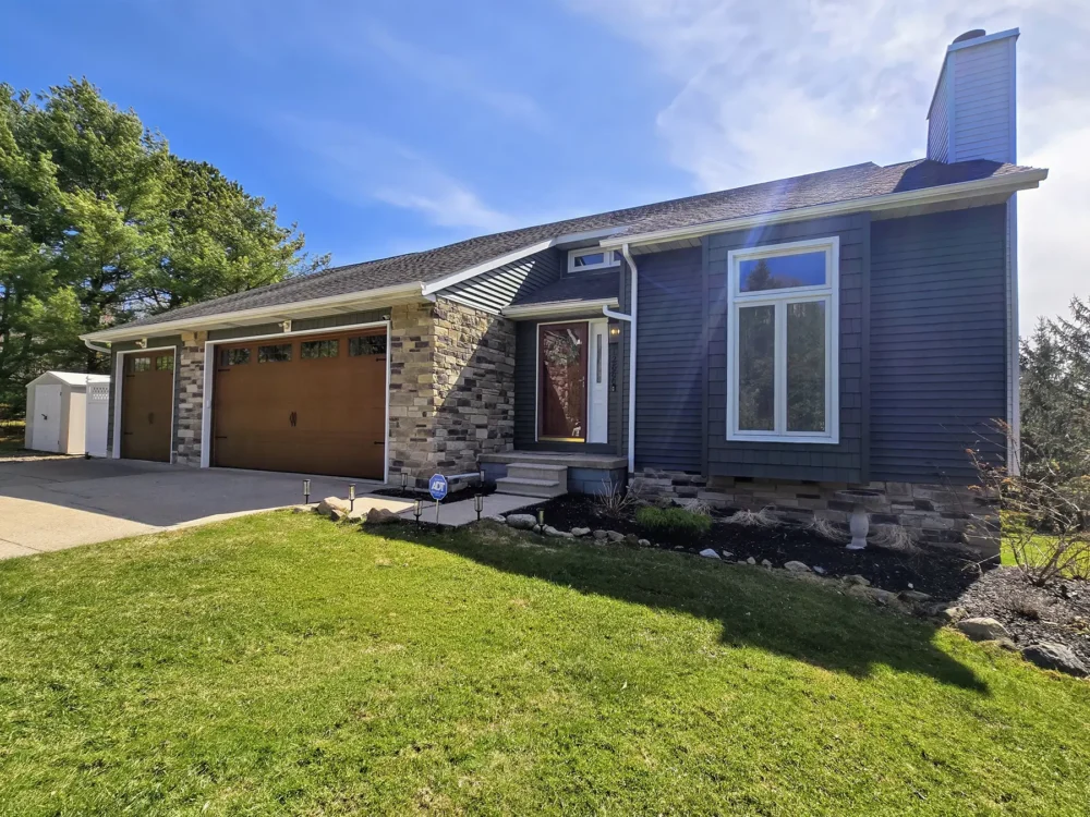 New siding, stonework, garage doors, and gutter installation